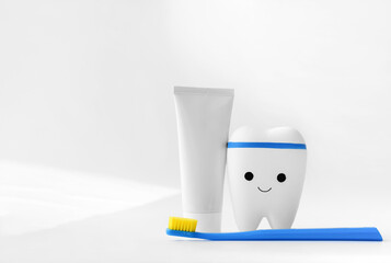 toy tooth, toothbrush and toothpaste on white background. signboard for stomatology, dentist office or denal care clinic. kids oral hygiene. copy space for advertising or text