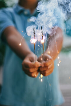 Child holds smoky sparklers on the 4th of July