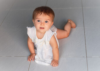 happy baby crawling on the tiled floor