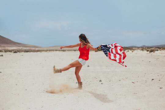 Woman With USA Flag Kicking the send of the Desert