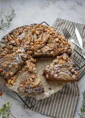 Brownie pie with pear and hazelnut on a grey background, food