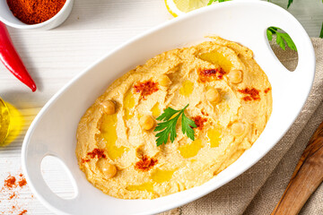 hummus paste with lemon and chilli on white background