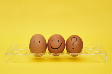 Chicken eggs in an egg stand. Tray for eggs. Half an egg, egg yolk, shell. Emotions and facial expressions on eggs, a question mark on an egg. Black egg.