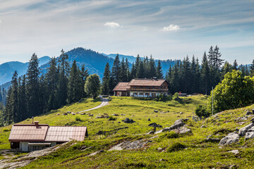 Reit im Winkl, Germany - 17th July 2020: A german photographer visiting the Winklmoosalm in Bavaria, taking pictures of a farm building on a meadow at a sunny day in summer. © ms_pics_and_more