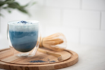 blue matcha tea with latte foam in a glass