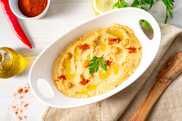 hummus paste with lemon and chilli on white background