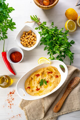 hummus paste with lemon and chilli on white background