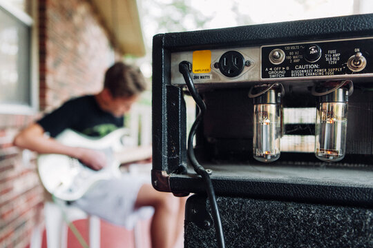 Vintage amplifier with young man playing guitar