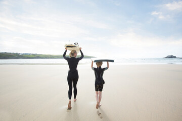 Mother going surfing with her Son.