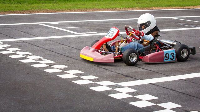 Young race kart driver about to cross the finish line