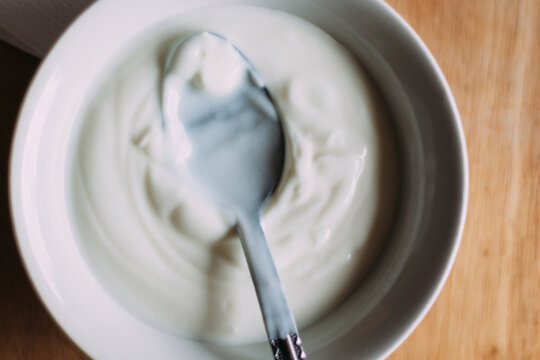 Bowl of Yogurt With a Spoon . Close up