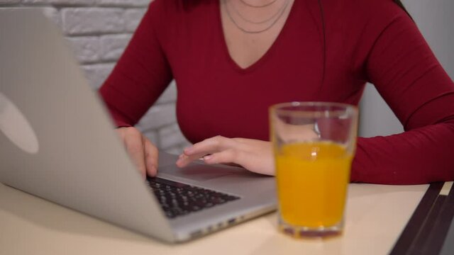Woman use laptop, freelance distance remote working, drinking orange juce