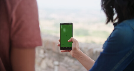 Romantic couple taking a selfie or using green screeen smartphone device in rural town of Assisi.Portrait medium shot.Friends italian trip.