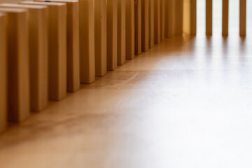 Wooden block domino standing stable on wood table, business chain and connection symbol, domino effect theory