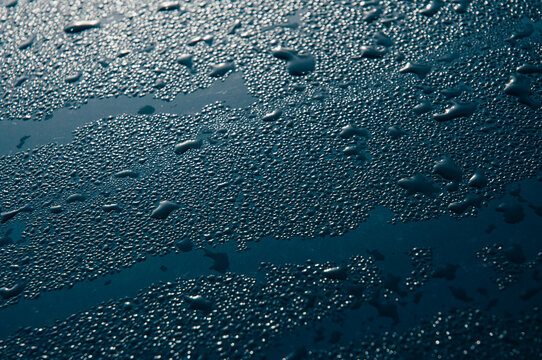 Close up image of water drops on dark metal,