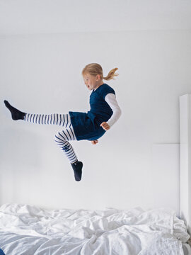 Girl jumping on bed