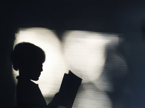 Shadow of a child reading a book