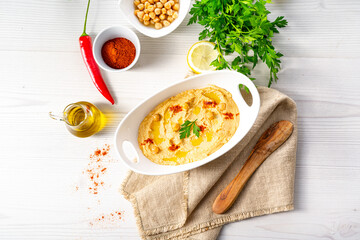 hummus paste with lemon and chilli on white background