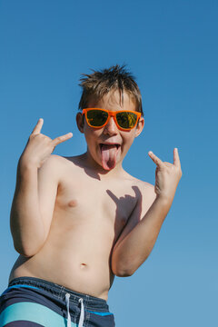 Funny Boy doing th Horn Hand Sign in a Summer Day