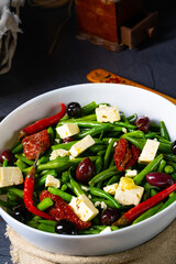 Spicy green bean salad with olives, feta cheese and dried tomatoes
