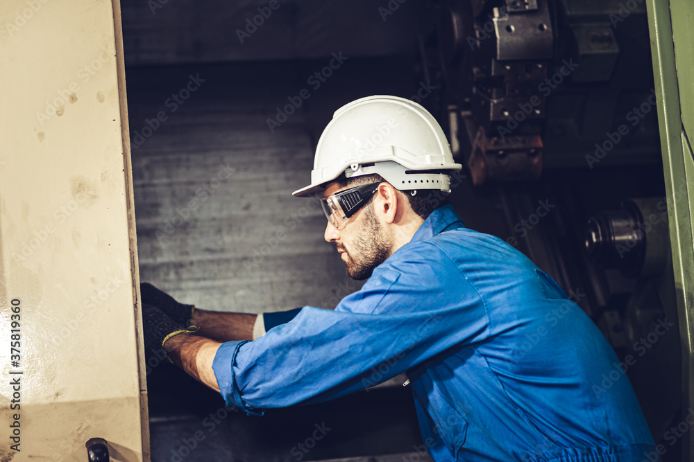 Wall mural Engineer worker service fix and repair checking inside CNC machine in heavy metal industry factory.