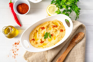 hummus paste with lemon and chilli on white background