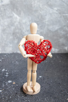 Wooden mannequin with red rattan heart.