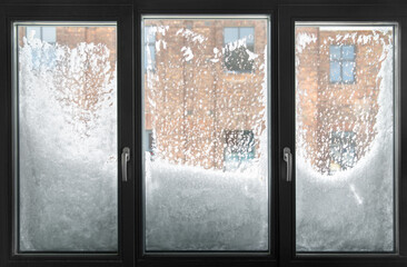 winter weather concept - window glass covered with snow after blizzard