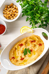 hummus paste with lemon and chilli on white background