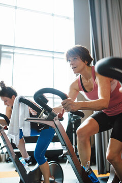 Happy middlle aged woman enjoying working hard during spin cycle class