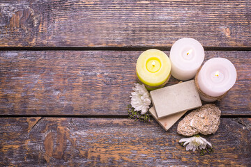Natural aromatic handmade soap and candles on a wooden background, top view, copy space.