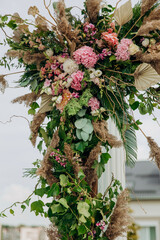 Wedding decor. The arch is decorated with different colors flowers.