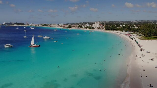 Aerial over the beautiful beach in Barbados. Flying along the beach over turquoise water  and boats.