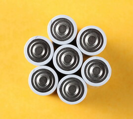 Batteries pile on orange surface background and texture