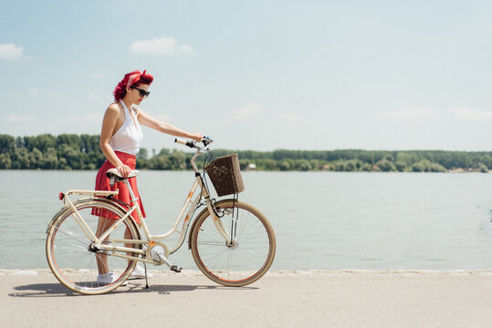 Young pin up woman riding a bicycle