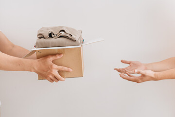hand holding box give clothes together for concept donation and reuse recycle