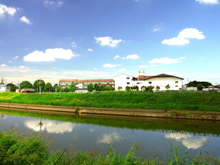 Fototapeta na wymiar 夏の放水路越しに見る小学校風景