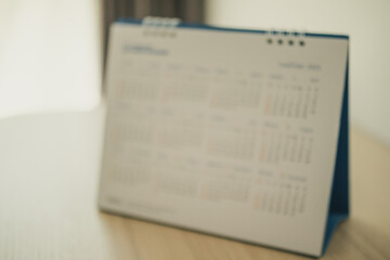Fototapeta premium Blur calendar page close up on wood table background business planning appointment meeting concept