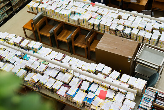 Piles of books tied with string on table in library
