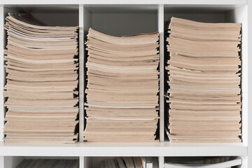 Piles of old magazines in a book shelf