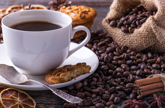 Coffee cup with aromatic hot beverage and baked cookies.