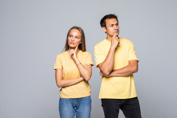 Fototapeta premium Concentrated man and woman looking aside while thinking isolated over gray background
