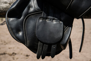 Close up elements of black leather saddle for horse.