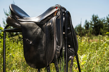 Close up elements of a black leather saddle for a horse.