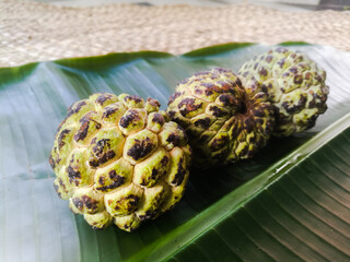 Custard apple placed isolated on a banana leaf.