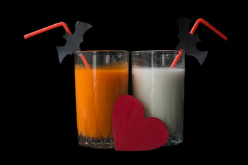 Festive homemade cocktail for Halloween. Cute Halloween drinks are white, orange and red hearts that symbolize love for this holiday. Isolated on a black background.