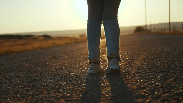 child jumping on a skipping rope close-up legs slow motion video silhouette. happy family kid dream concept. baby feet jumping on a skipping rope. girl in sneakers sunset play a skipping rope