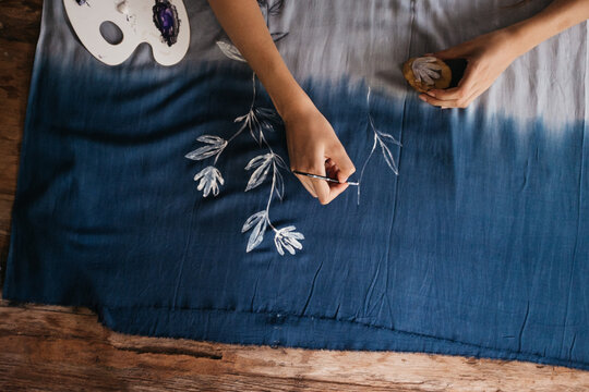 Female Artist Painting Flower Pattern on a Blue Fabric