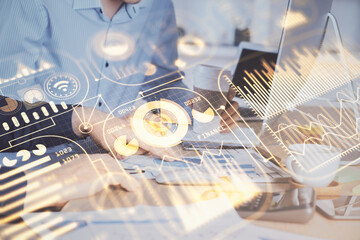 Technology theme hologram with man working on computer on background. High tech concept. Multi exposure.