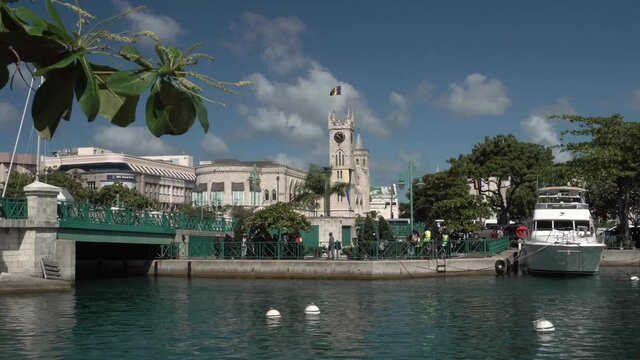 Bridgetown / Barbados - December 2019: A view on the Parliament building, Chamberlain bridge and small boat moored in the Constitution river from the Heroes Square